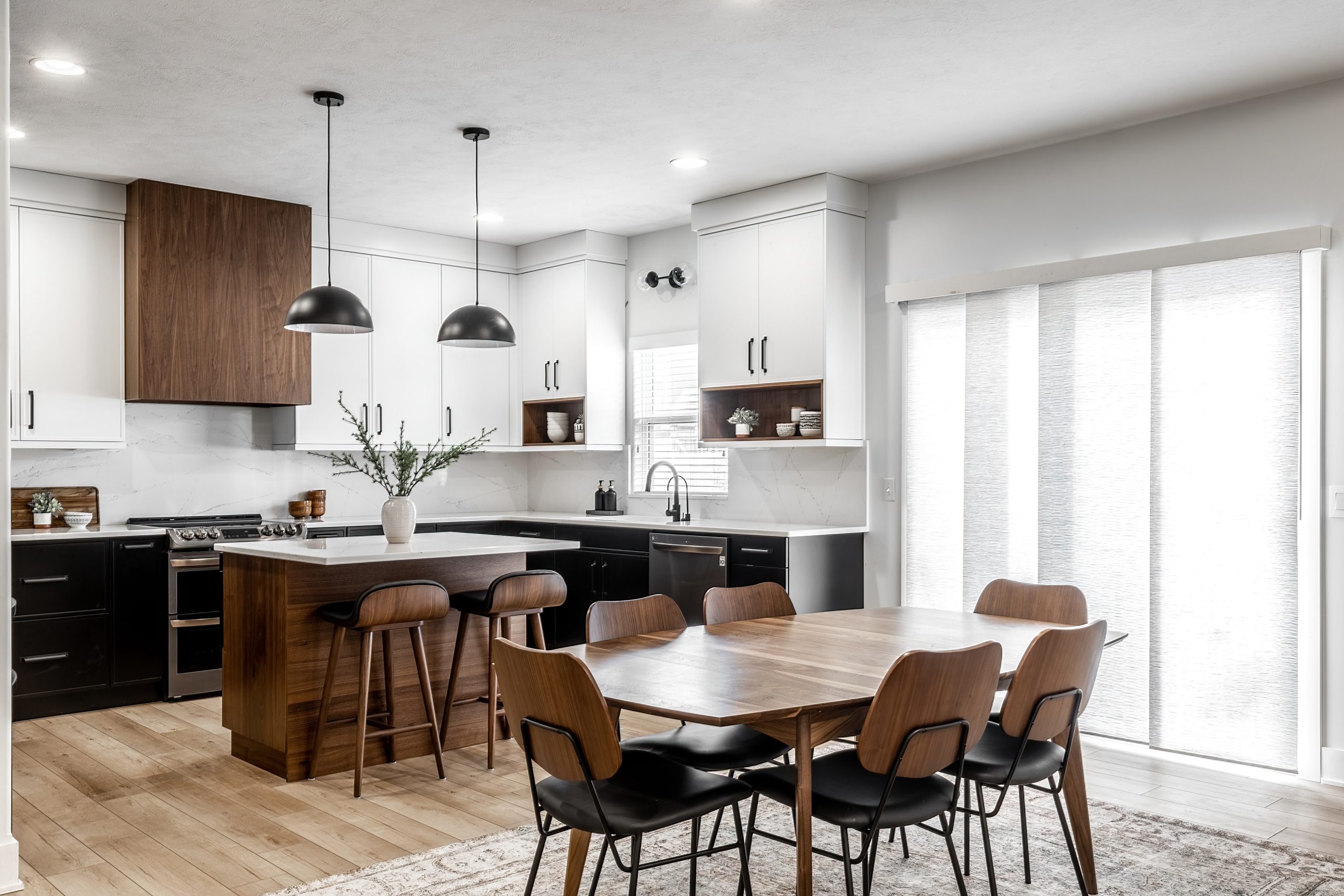 Midcentury modern kitchen with black and white cabinets, matte black fixtures, white quartz countertops and backsplash and walnut wood furniture interior design